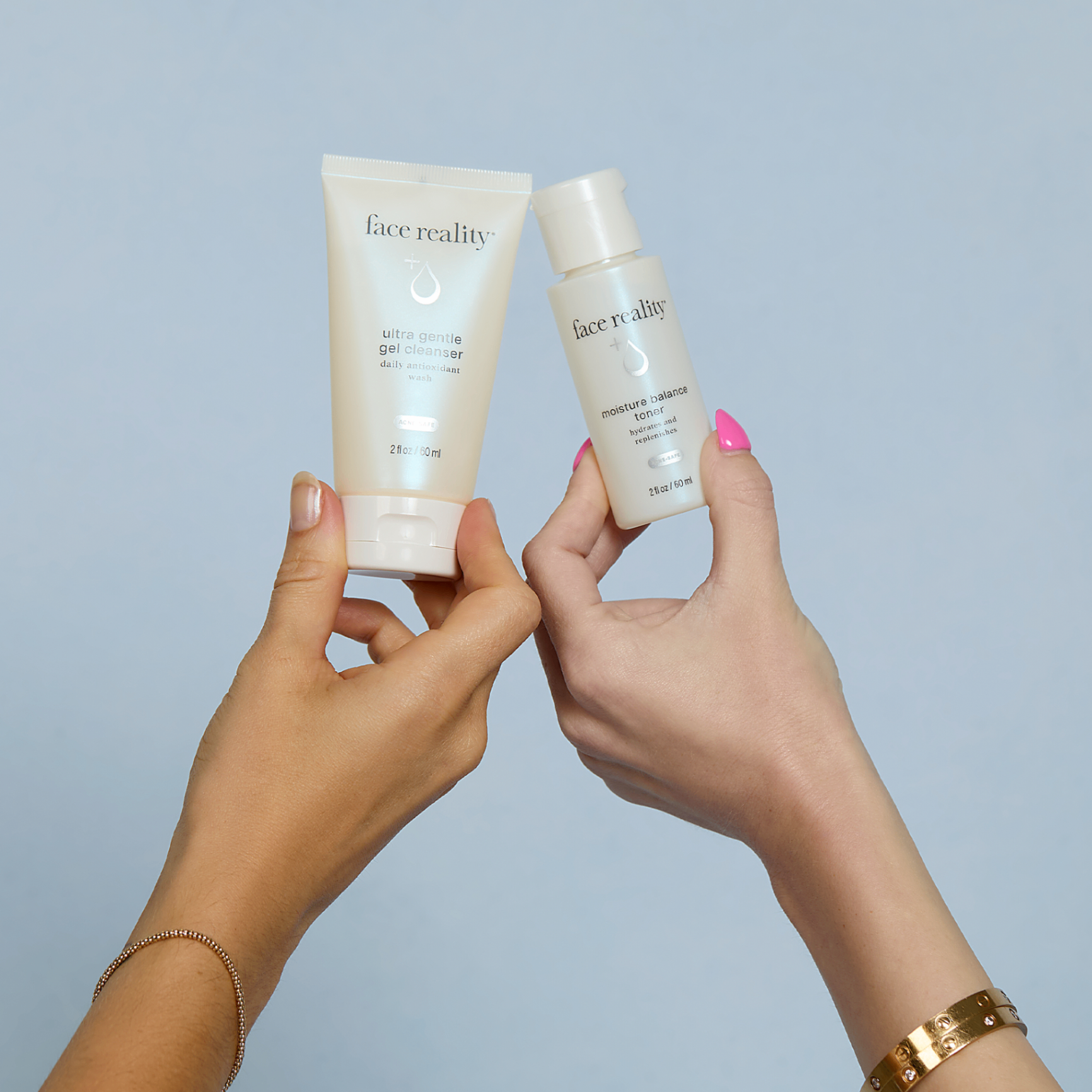 Face Reality acne-safe cleanser and toner held up against a soft blue background