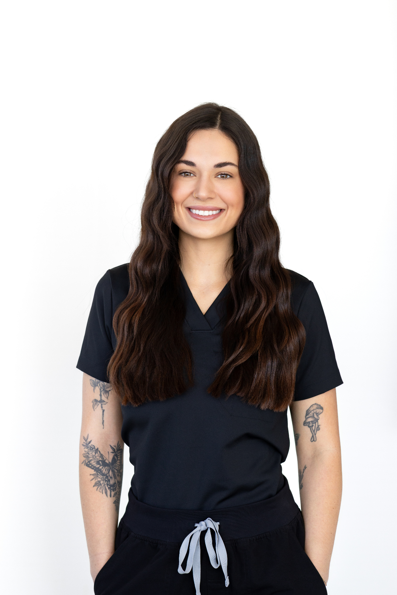 Gena Cockrell, founder of Glo Haus — full-length portrait in black scrubs